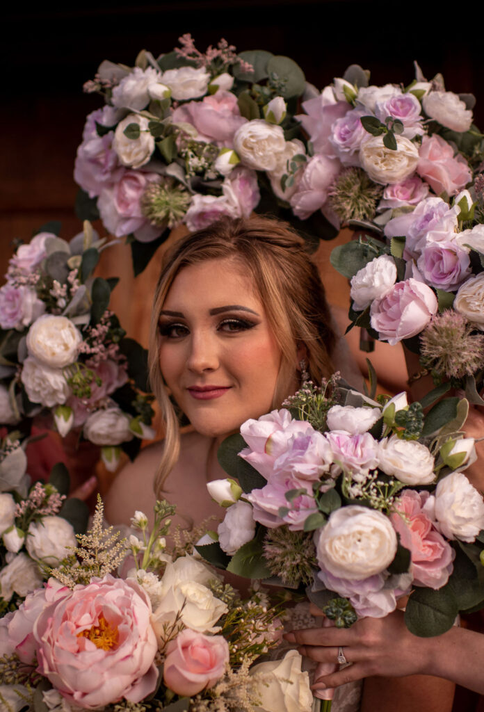 Brides headshot surrounded by bridesmaids bouquets 