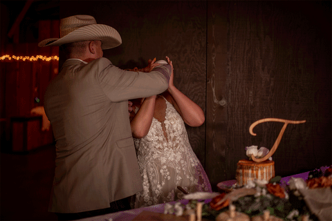 groom smashing cake in brides mouth