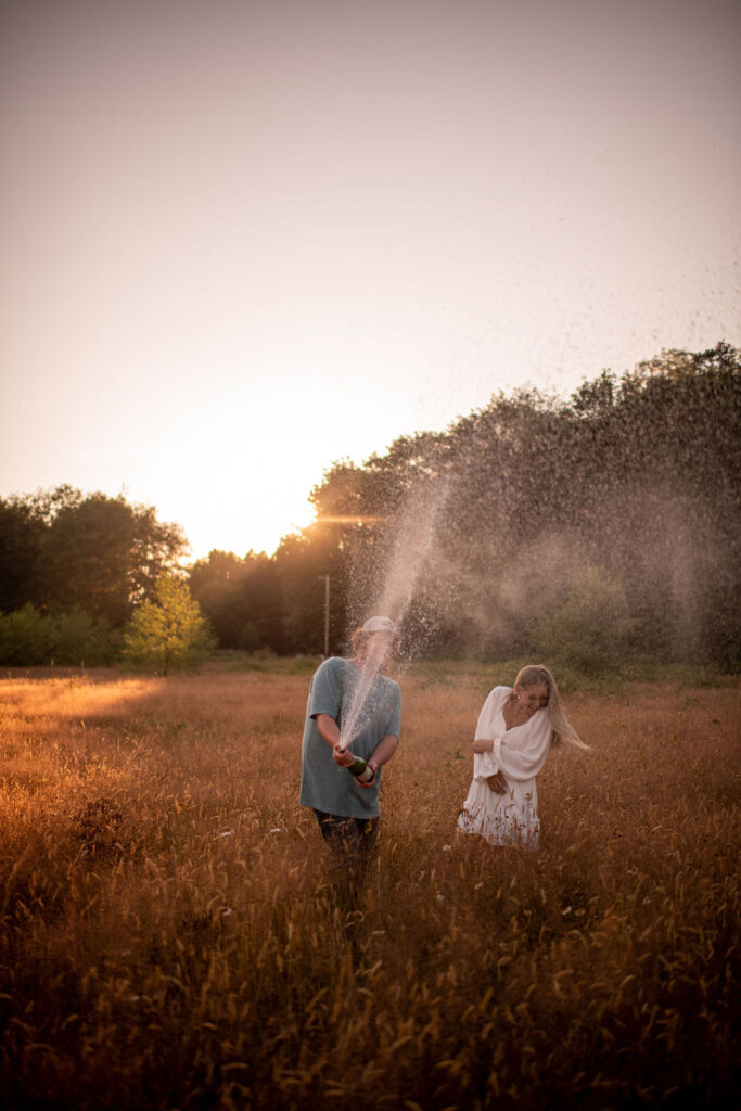 Couple popping champagne during their engagement session in Washington