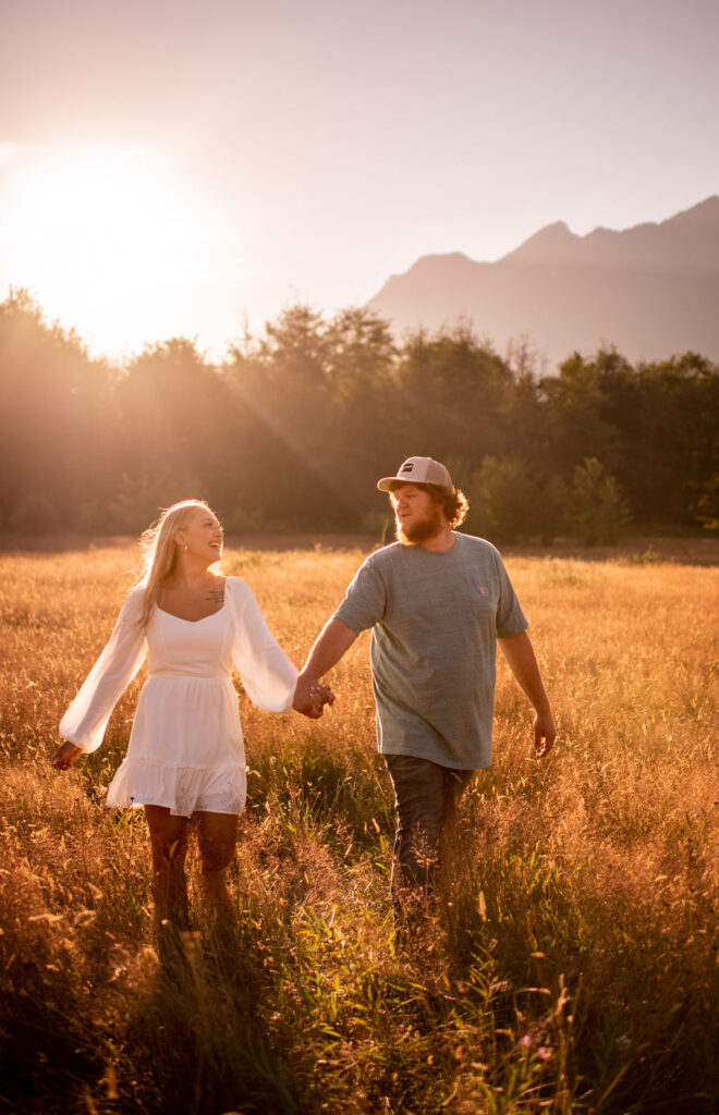 Couple holding hands in a washington field for engagement photos