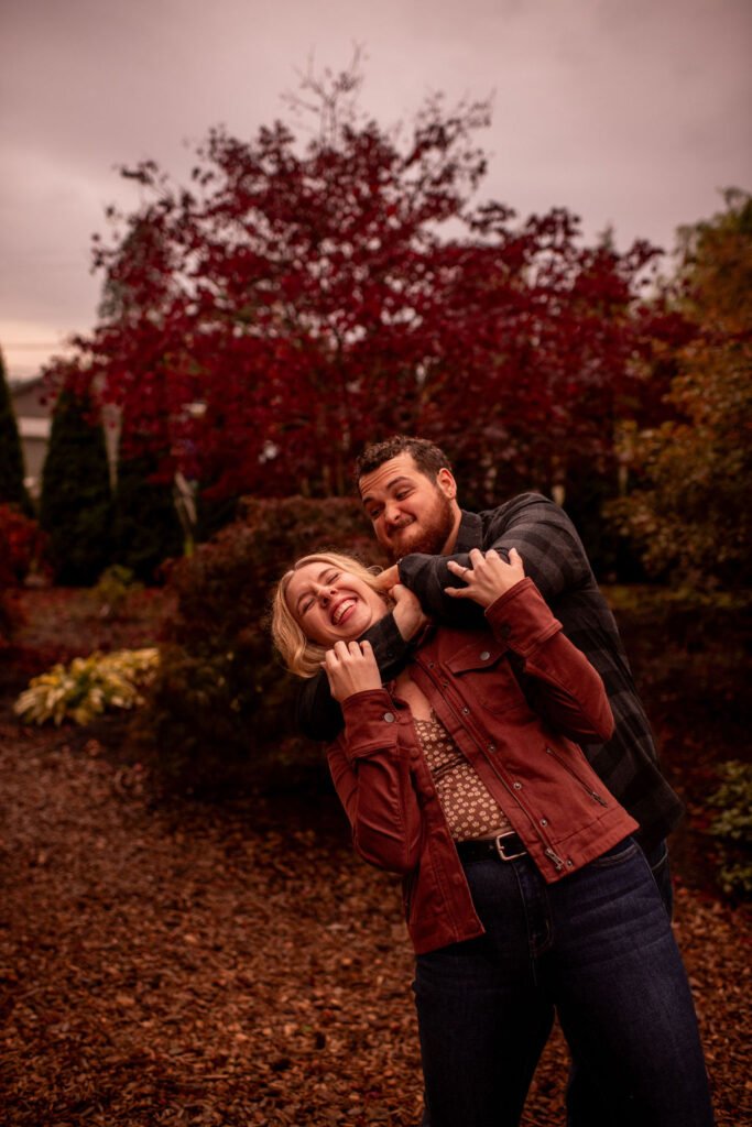 Funny moments of the engaged couple with evergreen arboretum gardens as the backdrop