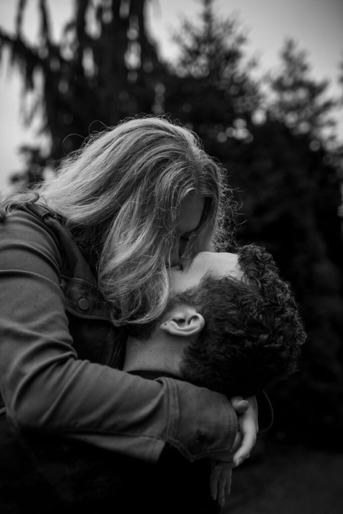 black and white picture of a couple kissing each other during their engagement photoshoot