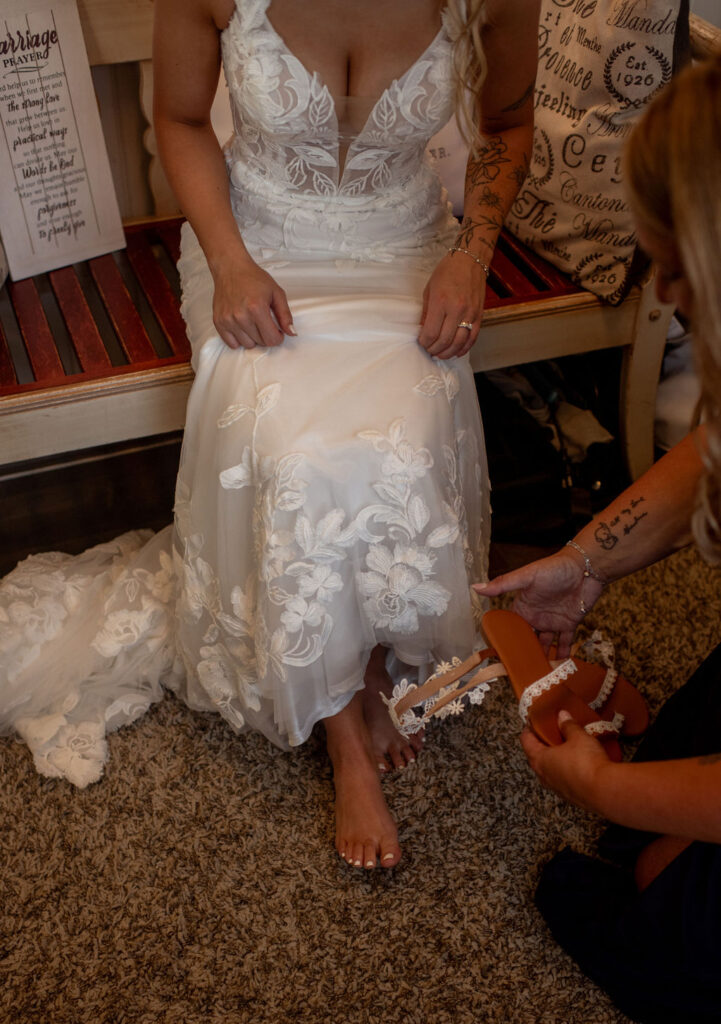 Bride putting her sandals before her ceremony at her fall wedding day