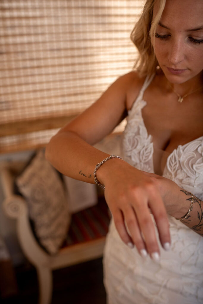 gorgeous bride putting on jewelry before her ceremony