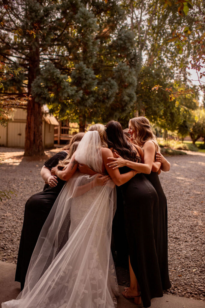 bride and bridesmaids hugging each other