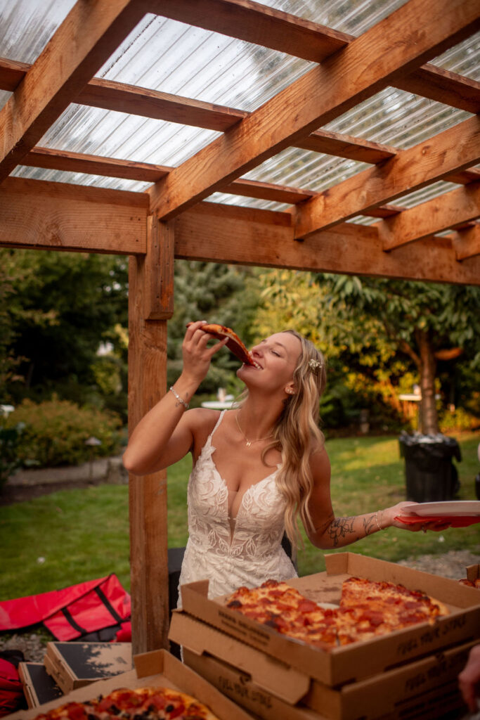 gorgeous bride eating pizza at her reception