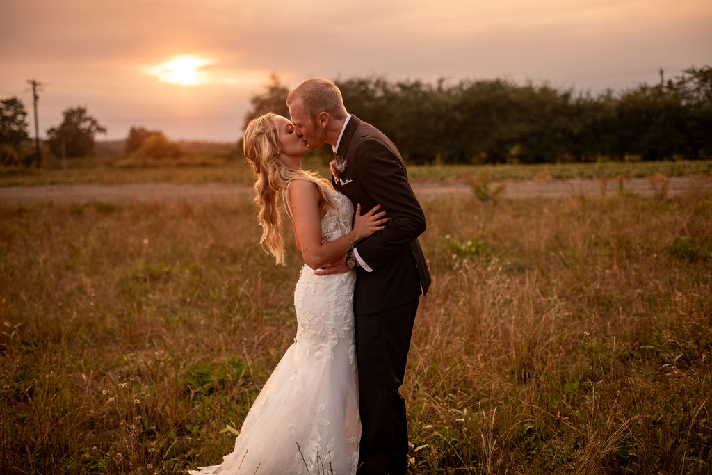couple kissing with the sun in the background 