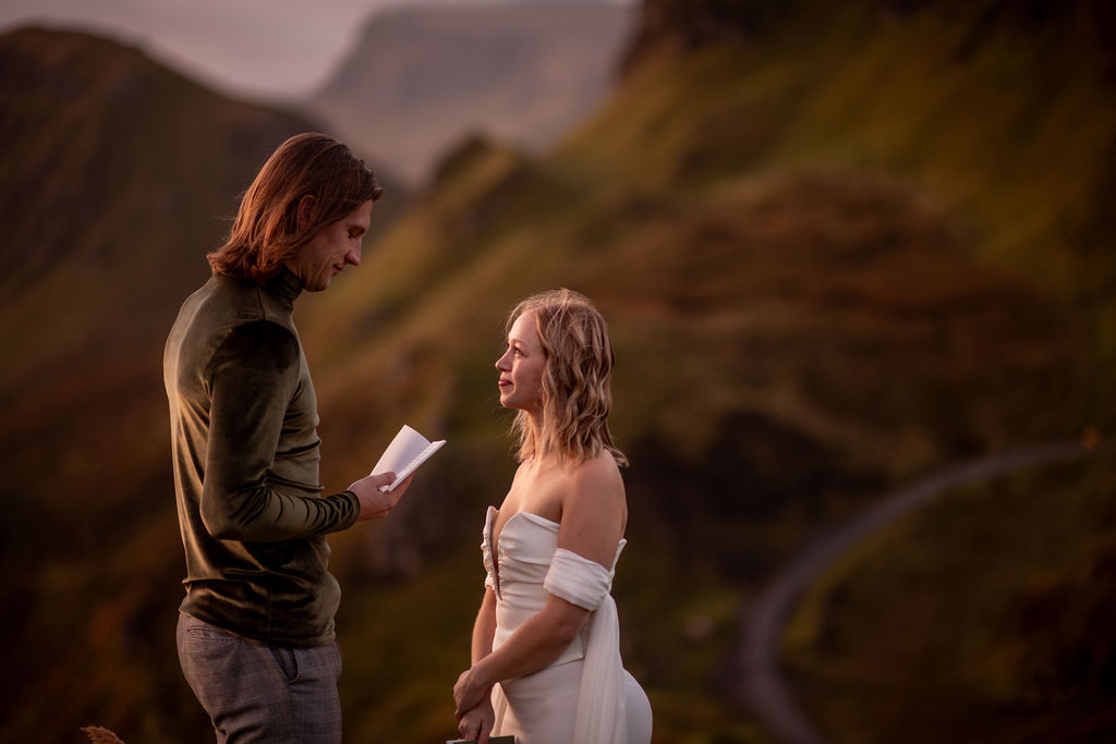 couple reading their vows at quiraing in scotland during their adventurous elopement 