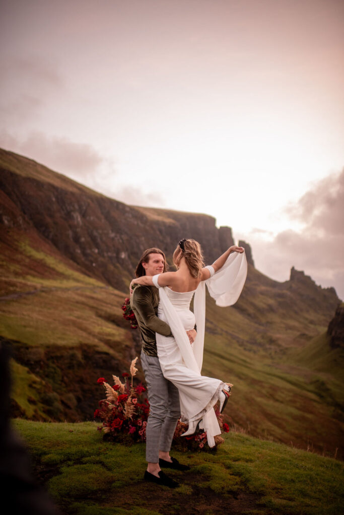groom picking up the bride at quiraing in scotland heights