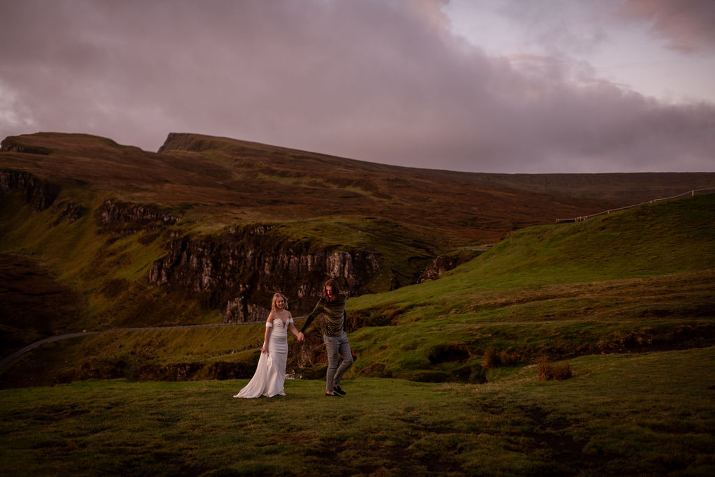 couple holding hands walking at quiraing in scotland heights